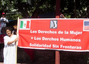 The speeches, placards, and banners were in both Spanish and English. This one reads: "Women's Rights = Human Rights. Solidarity without Borders."